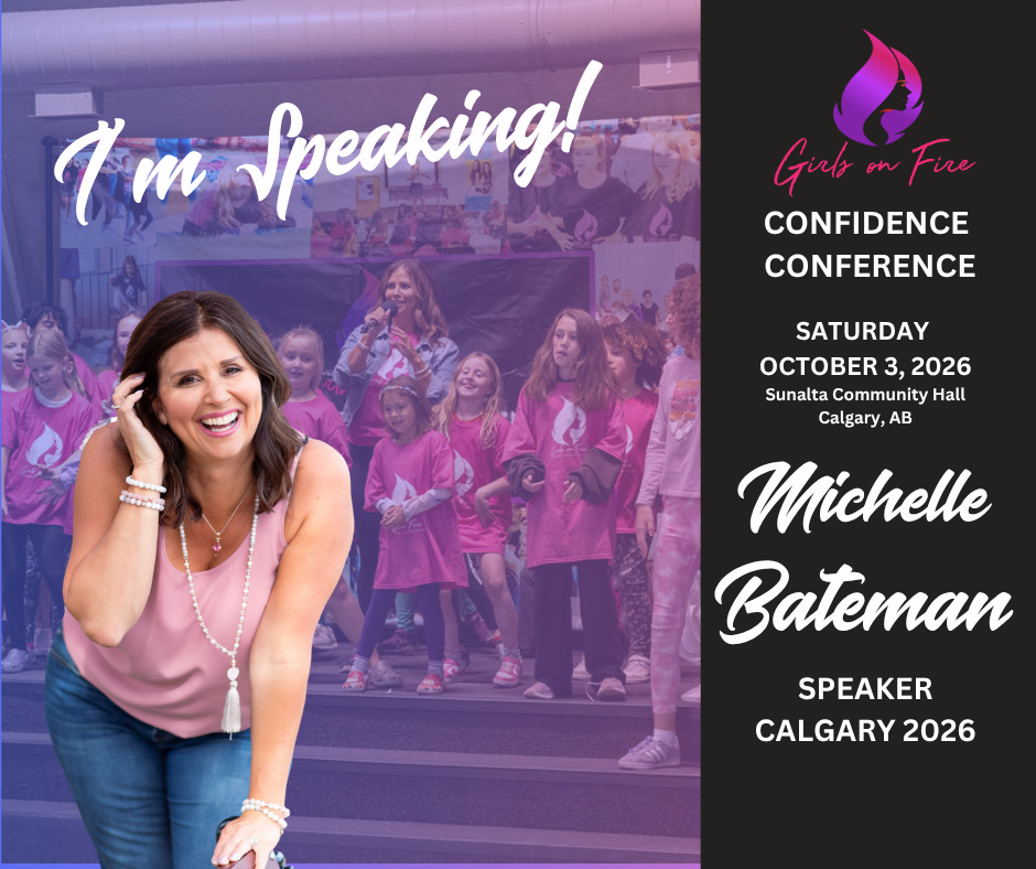 A smiling woman leans forward, wearing a pink top and pearl necklace. Behind her, girls in matching shirts cheer on stage. Text reads, “Girls on Fire Confidence Conference, Oct 3, 2026, Calgary—Michelle Bateman, Speaker.” Join Calgary's empowering event!.